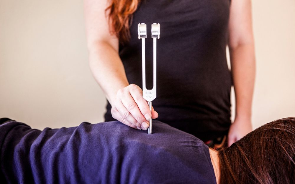 Un diapason thérapeutique en contact avec le dos d'un patient