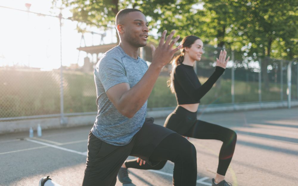 2 sportifs, un homme et une femme, au départ d'une piste d'athlétisme